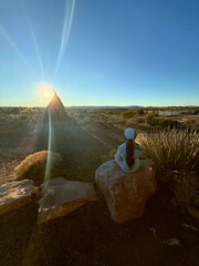 Child watching the sunset near a desert teepee at golden hour © Jorge