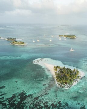 Aerial view, sailing boats between several small tropical palm islands, San Blas Islands