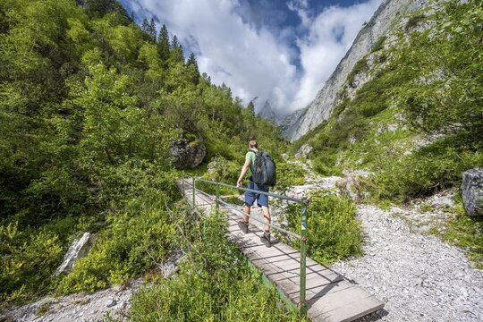 Mountaineer on bridge over the Hammersbach, at the end of the H&ouml;llentalklamm, Wetterstein Mountains, Garmisch-Partenkirchen, Werdenfelser Land, Upper Bavaria, Bavaria, Germany