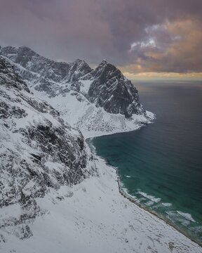 Aerial view, Kvalvika beach in winter with snow, Ryten mountain tops, Fredvang, Lofoten, Nordland, Norway