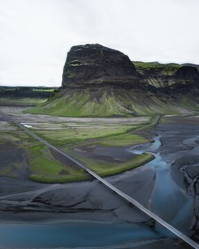 Aerial view, lava sand plane Skeidararsandur with road in front of rock massif Lomagnupur or L&oacute;magn&uacute;pur, southern Iceland