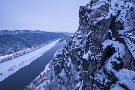 View at dusk from Bastei Bridge into the Elbe Valley with snow, Elbe Sandstone Mountains, Saxon Switzerland National Park, Saxony, Germany