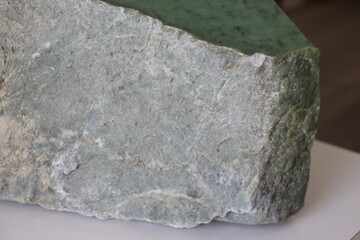 Close-up of a nephrite jade from Quebec. Green stone background and jade. Raw and polished jade. Geology science and mineral from Quebec. © Martine