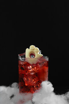 Spooky Halloween Drink with Ghost Garnish and Ice Cubes on Black Background Festive Holiday Beverage