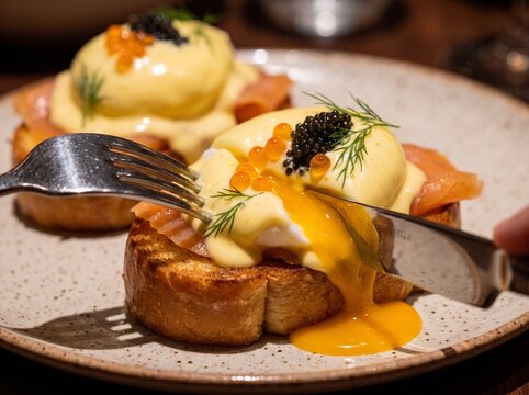 Delicious eggs Benedict with smoked salmon and caviar on toast  