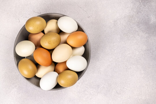 Organic farm fresh eggs in a bowl on a light background