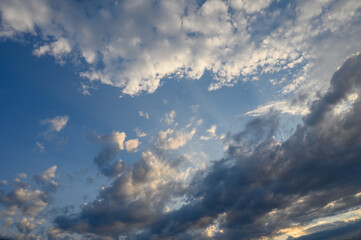 Obraz premium Clouds dance in the twilight sky, painting a breathtaking canvas above a serene landscape