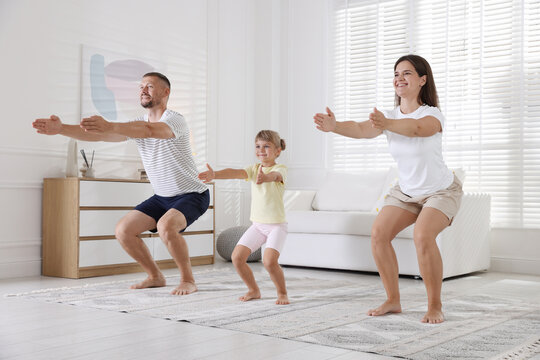 Happy family doing morning exercise together at home