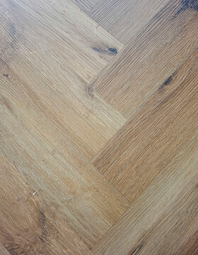 Warm oak wood parquet floor with herringbone pattern used in home interior design for style and function