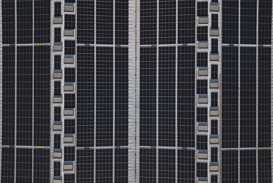 Portugal - 14 August 2026: Aerial view of solar panels installed on industrial factory rooftops, showcasing decentralized energy production.