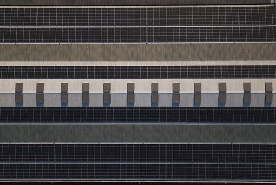 Portugal - 14 August 2026: Aerial view of solar panels installed on a large industrial factory rooftop, showcasing decentralized energy production.