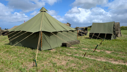 US Army World War II military camp with pyramidal tent and military vehicles.  © Inha