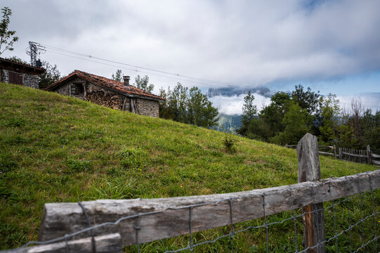 Rustic wooden gate opening onto a rural mountain field