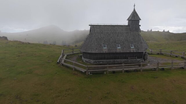 Aerial view of the chapel of Snows Mary on Velika Planina, Slovenia. Foggy weather over the traditional herdsmen's settlement