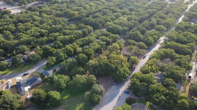 Quiet asphalt dead ends border green community recreation areas near Hurst Community Park. Shaded roof planes, parked vehicles, playground borders illustrate peaceful neighborhood life, Texas