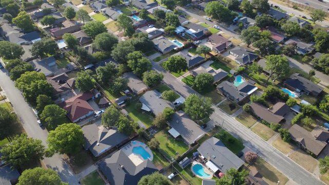 Sparkling blue swimming pools dot fenced residential properties south of Airport Freeway. Shaded patios, private driveways, lush tree cover characterize suburban tranquility, Hurst, Texas