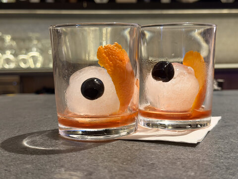 Two drinks at a bar in the shape of a funny set of eyeballs in a glass