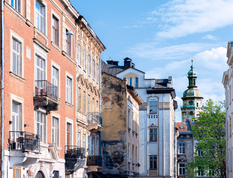 Historic European city street with aged buildings and a prominent clock tower