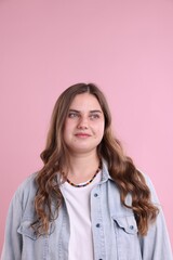 Fototapeta premium Plus size model in denim shirt on pink background. Beautiful young overweight woman