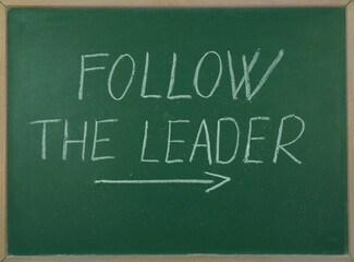 Follow the lider chalk text with arrow on green blackboard © Predrag