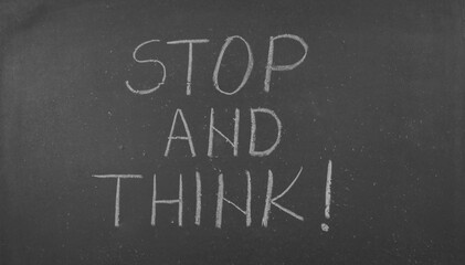 Stop and think text written on blackboard © Predrag
