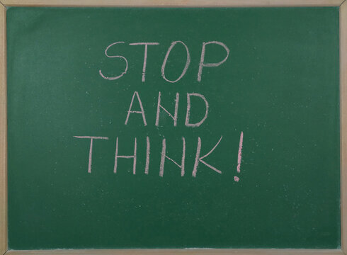 Stop and think text written on a school board