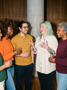 Diverse friends socialize and laugh at an indoor gathering
