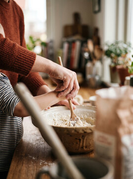 Child Helping Stir in the Kitchen