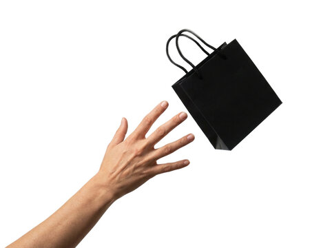 Hand reaching for falling black shopping bag, transparent background