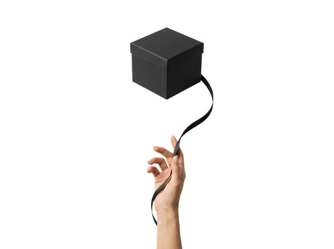 Minimalist black gift box floating over hand, transparent background