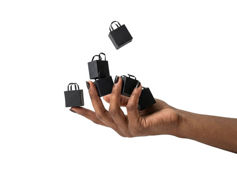Miniature black shopping bags in hand, transparent background