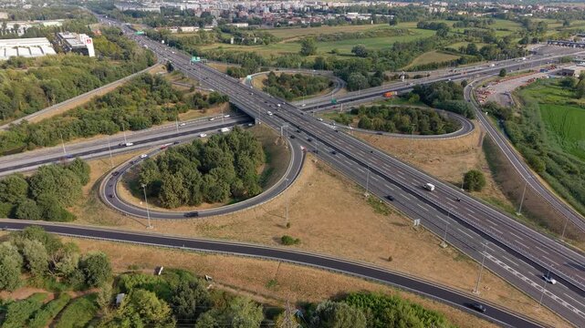 Aerial view of the A7 highway interchange at Assago near Milan, showing major roads, ramps and surrounding urban infrastructure within the metropolitan area.