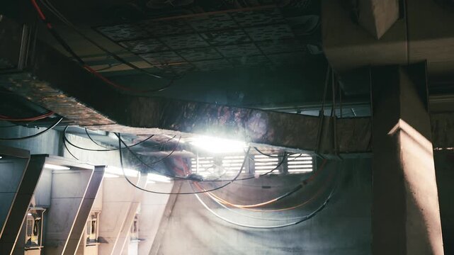 Abandoned industrial location shows intricate details of decay and mysterious lighting. Exposed wires, cracked surfaces, and beams create a captivating atmosphere of neglect and history.