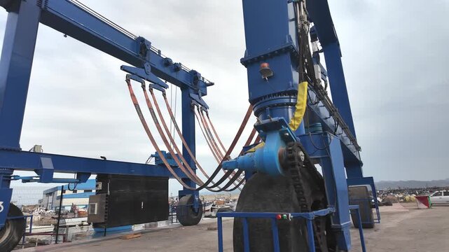 Large blue straddle carrier and gantry crane at industrial shipping port