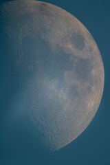 Prime focus astrophotography of half moon with surface craters in twilight blue sky Greece. © Bill Stefanis