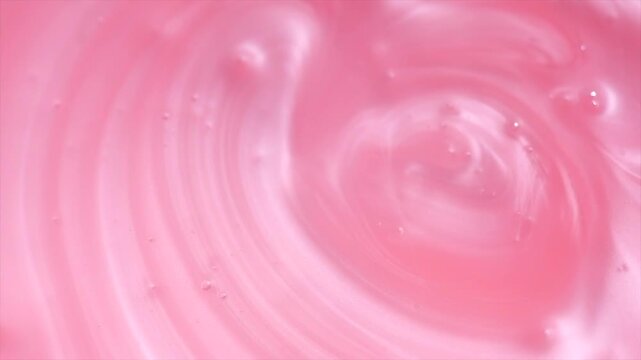 Pink liquid soap background. Pearlescent shower gel swirl texture, surface of liquid fluid, backdrop, shampoo texture, body care cosmetic, texture of liquid washing gel, soap backdrop top view, rotati
