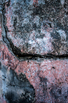 High-resolution commercial abstract background featuring a distressed concrete wall with peeling red paint, dark mold stains, and organic weathered textures from an outdoor location in Brazil.