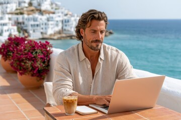 Fototapeta premium Man working on laptop at a seaside terrace enjoying remote work and coffee in a Mediterranean town