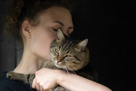 Woman Embracing Her Tabby Cat with Tenderness