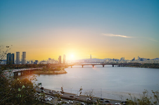 Scenery of Seoul city landscape with bridge railway transport over the han river and high way traffic light on golden sky could clear before sunset
