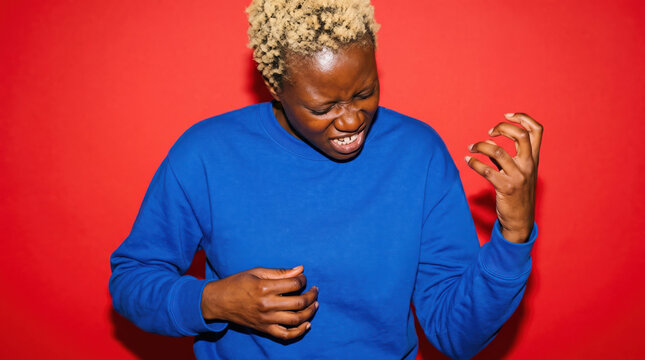 Person playing air guitar on a red studio backdrop