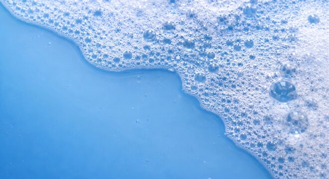 Blue soap foam bubbles forming abstract cleaning background