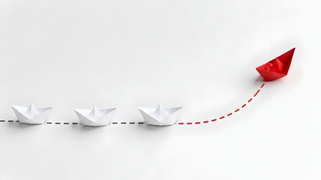 Business strategy concept with a red paper boat breaking away and moving upward on a dashed line representing growth and leadership success