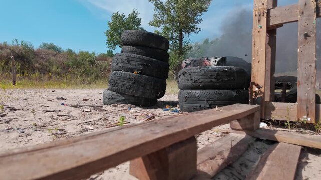 Target shooting impact on stacked car tires at an outdoor shooting range