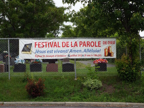 Gatineau, Quebec, Canada &ndash; June 26, 2026: A "Festival de la Parole de Dieu" banner is hung on a chain-link fence outside near some greenery on Bd Lorrain.