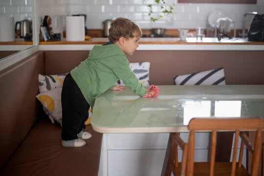 Toddler Boy Cleaning the Table with a Cloth After a Meal