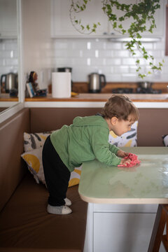 Toddler Boy Cleaning the Table with a Cloth After a Meal