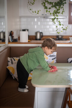 Toddler Boy Cleaning the Table with a Cloth After a Meal