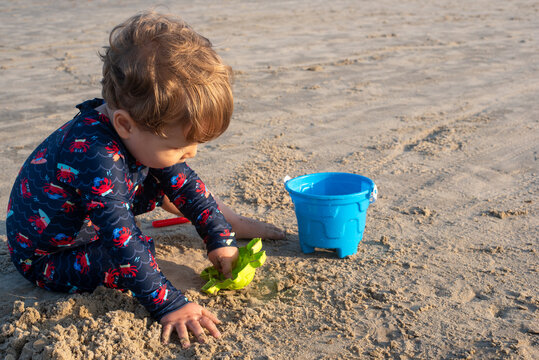Two-Year-Old Toddler Boy Playing in the Sand on a Beach