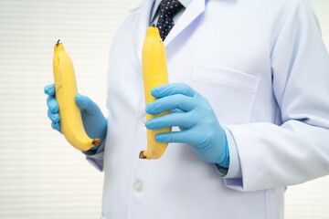 Male doctor stands holding a banana, penis health. © kanruthai